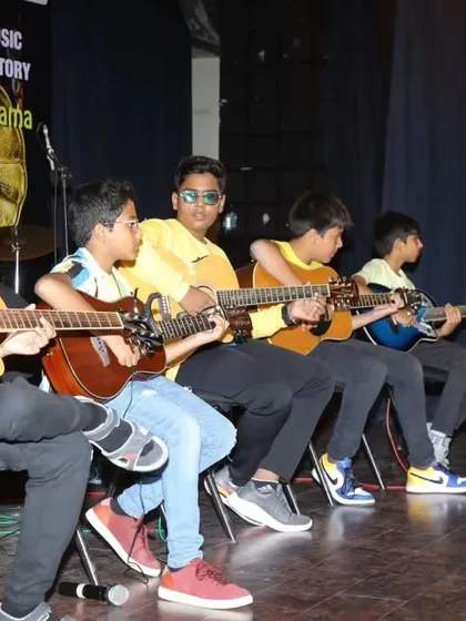 Our young guitarists lined up on stage for their 'Believer' cover.