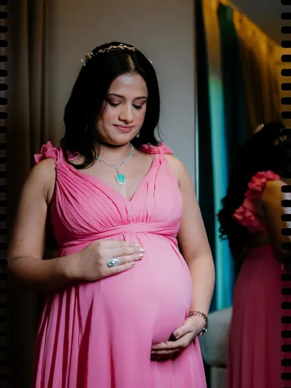 A quiet, reflective solo portrait of an expectant mother. The soft lighting and her gentle gaze towards her baby bump create a timeless and emotional image, beautifully capturing the anticipation of motherhood.