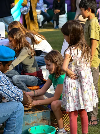 Children participating in a pottery workshop at the French Charity Mela. Our events are family-friendly and offer hands-on activities for all ages.