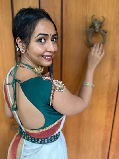A beautiful back design for Hitha Chandrashekar. This blouse features a deep cut-out with unique shoulder embellishments, showing how a blouse can make a statement from every angle.