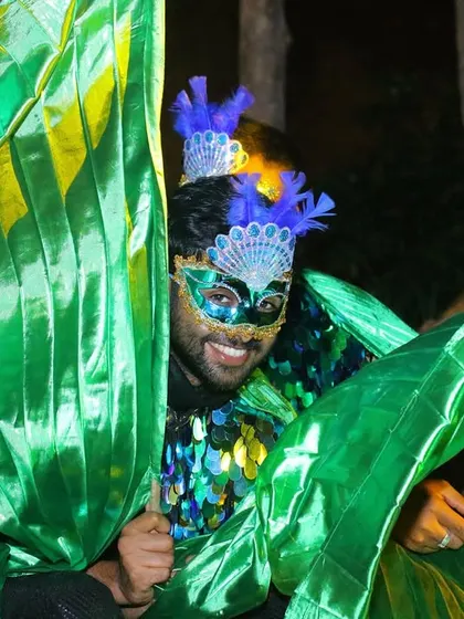 A male dancer in a magnificent green costume, ready to bring the energy of the carnival to the party.