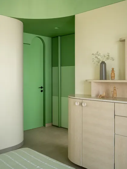 Another view of the son's bedroom, highlighting the custom joinery and the gentle curves that define the space.