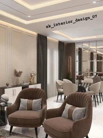 An open-plan living and dining area where we used furniture grouping to define the space. The living area features plush brown armchairs, while the dining zone is marked by a sleek table and chairs, all unified by consistent wall treatments and a neutral color palette.