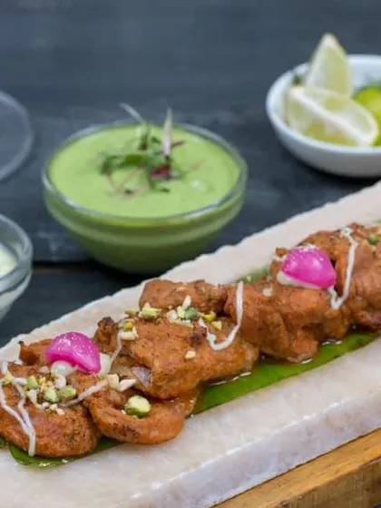 Another view of our nadru ke kebab, highlighting the pickled onion and pistachio garnish. These small details elevate the dish and add layers of flavor and texture.