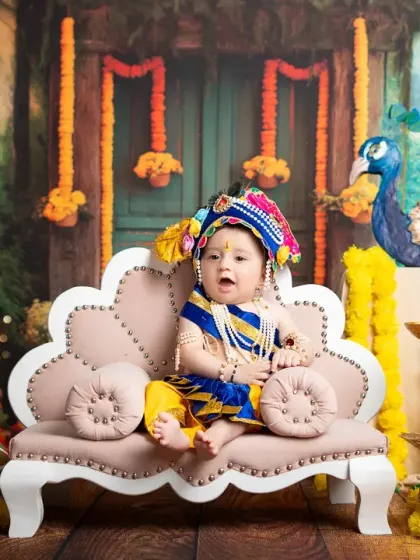A full portrait of a baby as Lord Krishna, showcasing the vibrant colors and detailed props of this popular themed session.