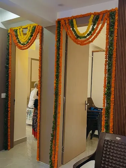 Doorways decorated with traditional marigold garlands for a housewarming or festive event. This adds a classic and welcoming touch.
