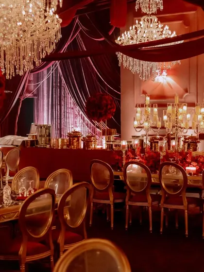 A wide view of the dining setup, showcasing the rows of tables adorned with grand candelabras and the magnificent chandeliers overhead. The scale of the decor is designed to impress.