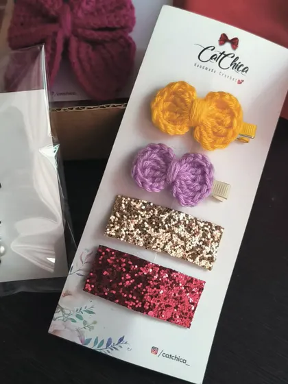 A mixed set of hair clips, featuring two crochet bows and two glitter barrettes.