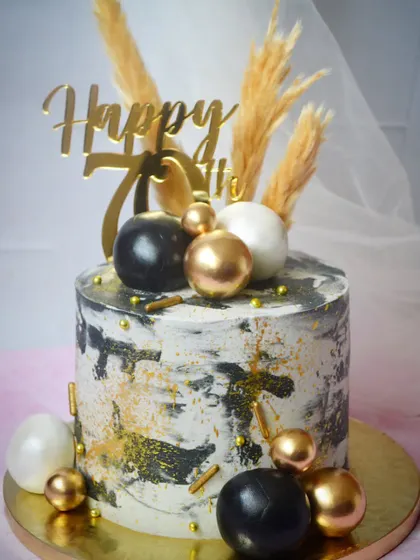 A cake with a soothing black, white, and gold color palette. The abstract, textured design is perfect for a sophisticated and modern celebration.