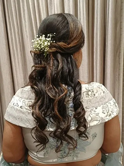 A detailed back view of the half-up hairstyle from the previous video, highlighting the twisted details and the fresh baby's breath accessory. The highlights in her hair add beautiful dimension.