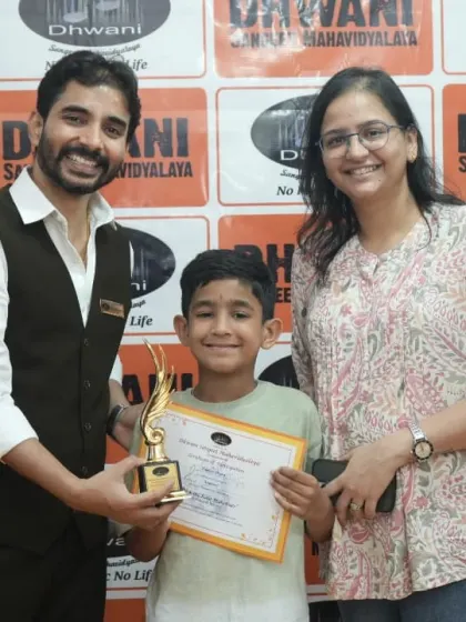 A student and his mother receive his award from the teacher.