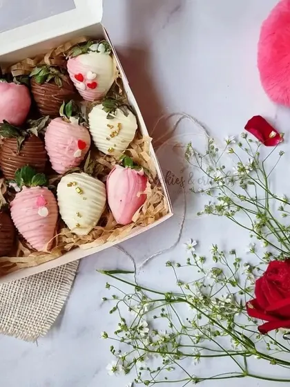 A box of assorted chocolate-dipped strawberries for Valentine's Day. The mix of milk, white, and pink chocolate makes them look extra special.