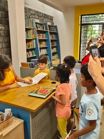 Parents capturing the special moment of their children getting a book signed by the author.