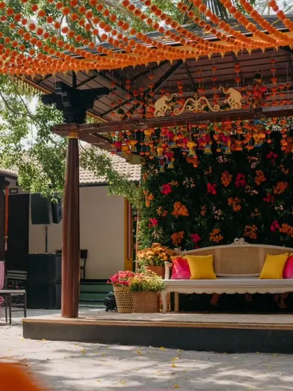 A view of the Haldi stage through the marigold decorations.