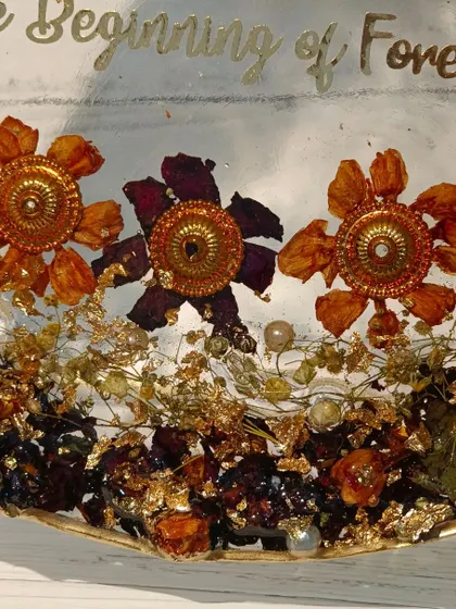 A close-up of a "Love" nameplate model. This design features preserved flowers from the wedding, along with unique elements from the varmala, creating a detailed and personal keepsake.