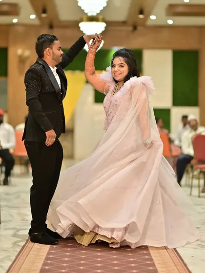 A joyful dance at their engagement party. The bride's voluminous pink gown moves beautifully, creating a fun and festive atmosphere.