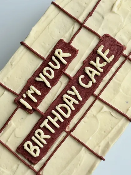 A close-up of the message on the gift-wrapped cake, showcasing the clean lettering and unique design.