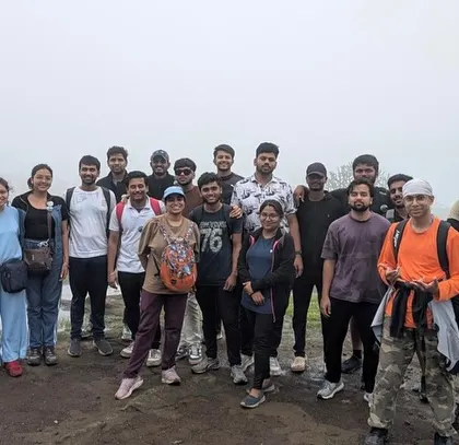A group of trekkers on the misty trails of Harishchandragad, a historic hill fort in Maharashtra.