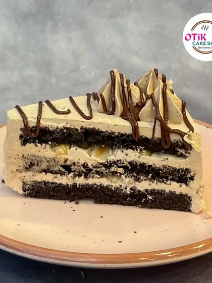 A slice of our Oreo Cream Pastry. This dessert features layers of chocolate sponge and a light, airy cream filled with crunchy Oreo cookie pieces.