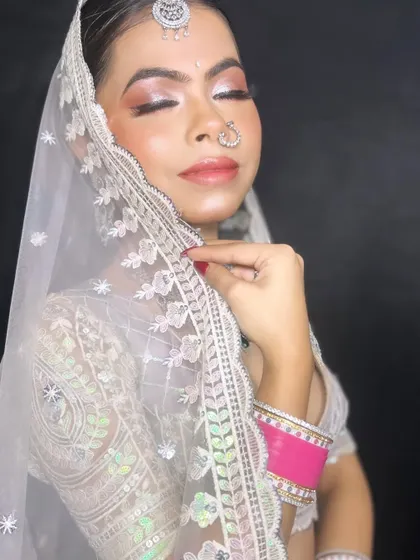 Elegance in every inch. This modern bride wears a beautiful white chikankari lehenga, and her makeup is kept soft and glowing with a touch of pink on the lips and shimmery eyes.