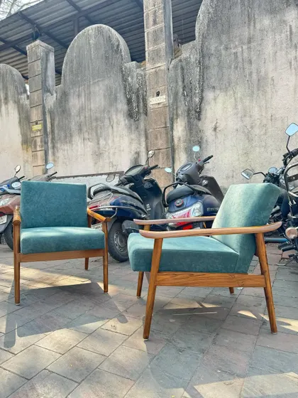 The chairs are shown from a low angle, highlighting the sculpted armrests.
