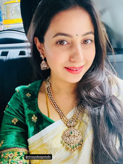 Soundarya looking beautiful in a selfie. She paired her off-white saree with a custom-designed rich green velvet blouse with delicate gold embroidery.