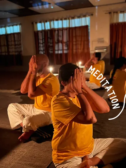 Students practice a breathing technique during a candlelit meditation session on a yoga retreat. The soft light helps to create a serene and introspective atmosphere, ideal for turning the focus inward.