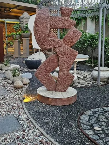 An abstract stone sculpture placed thoughtfully in a landscaped garden. We believe good design is about the perfect combination of nature and art.