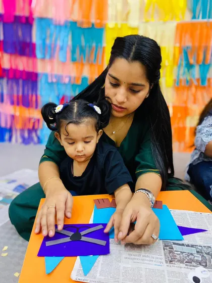 Against a colorful backdrop, a mother and daughter work on their craft, highlighting the vibrant and stimulating environment of our centers.