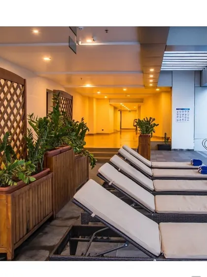 The poolside relaxation area at the Calicut hotel. Wooden planters and lattice screens create a natural, resort-like feel, providing a tranquil space for guests to unwind.