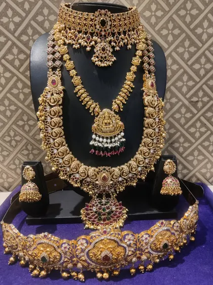 A beautiful Kempu bridal set with peacock and Lakshmi motifs, perfect for a grand wedding.