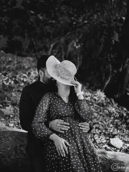 A playful and mysterious black and white shot where the woman hides their kiss with a hat. This adds a fun, creative element to the portrait while still conveying a sense of romance and intimacy.