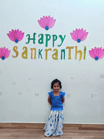 A little one poses in front of our 'Happy Sankranthi' decorations, looking lovely in her traditional dress.