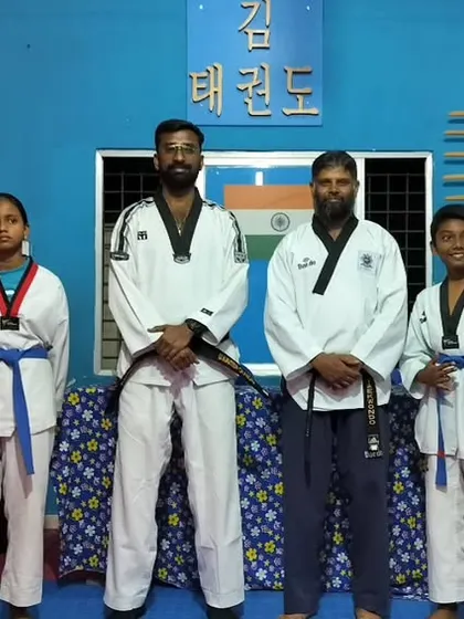 A group photo of our students after a successful belt promotion test. This picture includes students with new blue and red belts, standing proudly with their instructors.