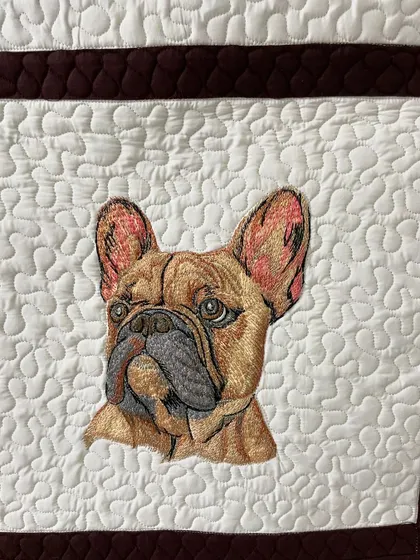A close-up of a French Bulldog portrait from a custom art quilt, showing the detailed embroidery work.