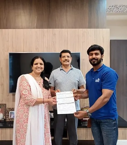A couple receives their solar agreement from our team member in their well-appointed living room.