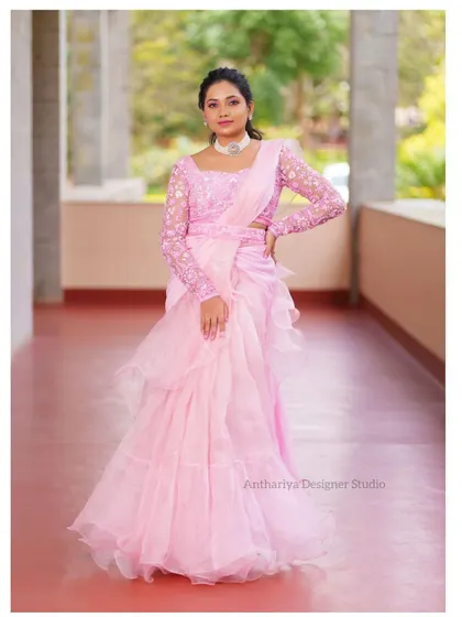 A model in a dreamy pink ruffled saree-lehenga, a modern and trendy option for any celebration.