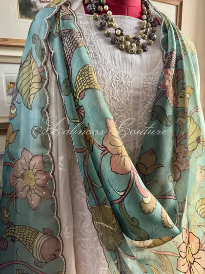 This image captures the elegant fall of the organza dupatta, with its hand-painted details and subtle embellishments, creating a look of effortless grace.