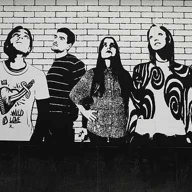 A high-contrast, black and white mural depicting figures against a brick pattern. This graphic style is effective for creating a bold, urban look in commercial interiors.