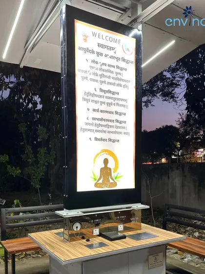A close-up of the illuminated digital screen on our solar hut in Chandigarh at dusk. The screen displays welcome messages and important information, blending seamlessly with the modern aesthetic of the unit.
