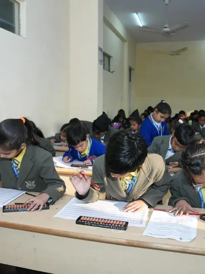 A classroom of students focused on their exam papers during the national level competition.