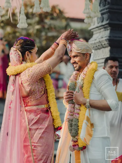 The garland exchange (Varmala) ceremony, a pivotal moment in the wedding. The bride's happy expression as she garlands the groom is a joy to witness.