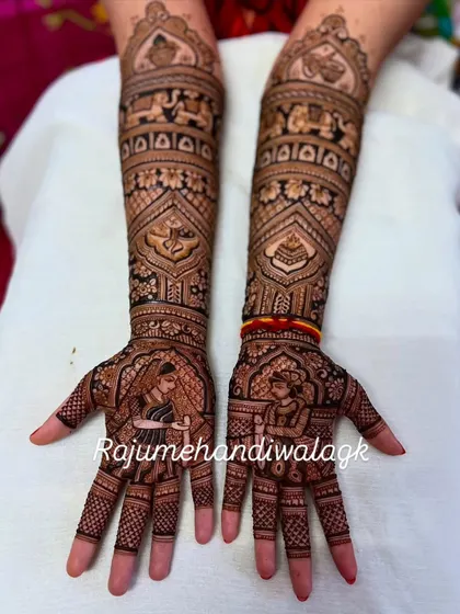 A beautiful example of bride and groom portraits on the palms. The rest of the design is filled with traditional motifs like elephants and paisleys, making the portraits stand out.
