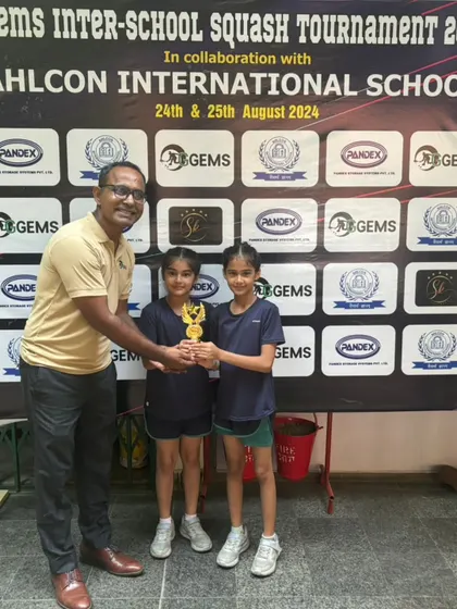 A proud moment with two young champions and their trophy at the Ahlcon International School tournament.