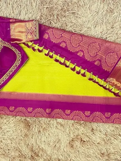 A vibrant neon green silk saree paired with a contrasting magenta purple hand-embroidered blouse.