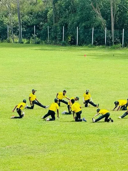 The team goes through their warm-up stretches on the lush green outfield in Sri Lanka.