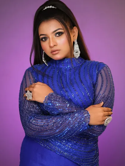 This pose shows off the dramatic long earrings and the clean, flawless base of the makeup.