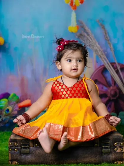 A little bit of heaven sent down to earth. The traditional pattu pavadai looks beautiful in our colorful setup.