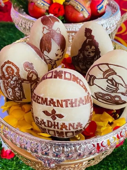 A beautiful set of custom-carved coconuts for Sadhana's Seemantham. The designs include traditional motifs like Krishna and a baby shower scene, making it a memorable keepsake.