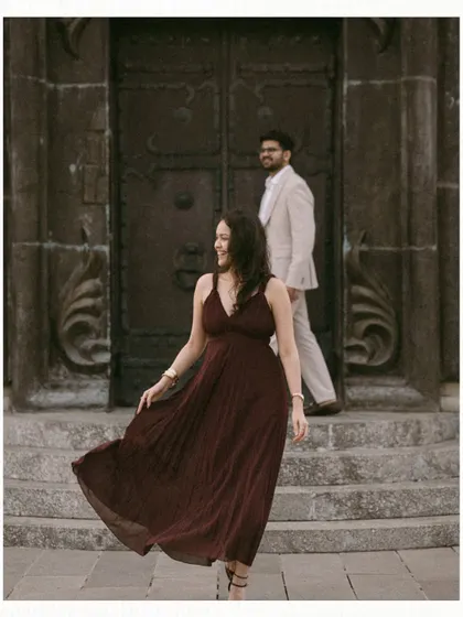 A beautiful, unposed moment in Georgia. The bride walks with a flowing dress down stone steps while the groom follows, his gaze entirely on her, capturing a natural and romantic interaction.